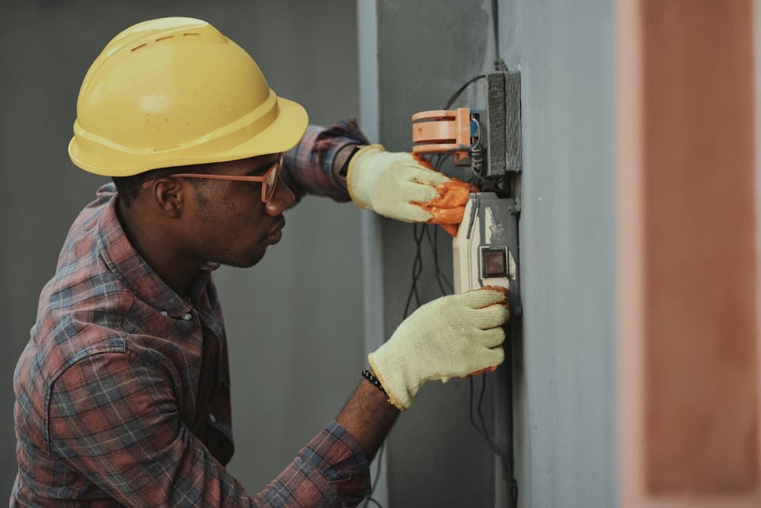 A professional electrician working carefully on a wall installation